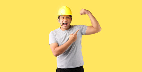 Asian man Industry worker or engineer working an architect builder Pointing finger isolated on yellow background in studio With copy space.