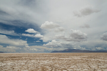 Mineral resources. View of the salt desert texture, mountains and beautiful cloudy blue sky. 