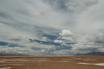 View of the arid desert. The vast brown field and mountains in the horizon under a beautiful blue...