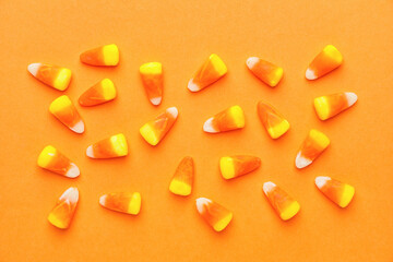Tasty candies for Halloween on color background