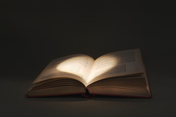 mysterious light draws a heart in the pages of a book of love