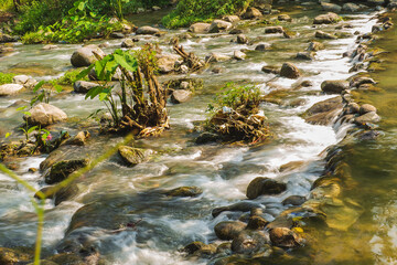 Water flows through the rocky rapids in a natural stream at Vang Vieng, Laos