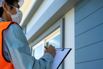 Inspector or engineer is checking and inspecting the building or house by using checklist. Engineers and architects work on building the house before handing it over to the landlord.