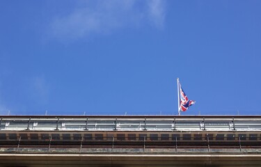 Blue sky with copy space with Union Jack flag above building