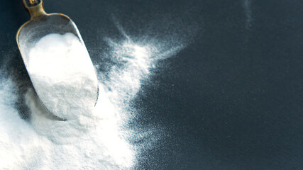 Glass bowl of baking soda. Spoonful of bicarbonate.
