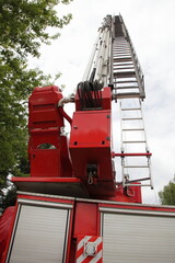 Modern red fire truck back view with tall extendable fire ladder close up in perspective , firefighter rescue equipment