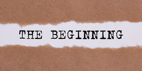 THE BEGINNING written under torn paper on white background