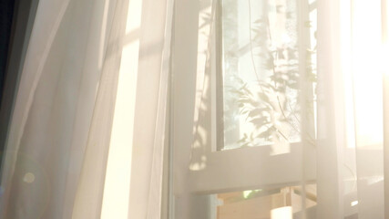 wind blows through the open window in the room. Waving white tulle near the window. Morning sun...