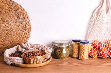 Variety of grains and legumes in glass jars and eco bags.