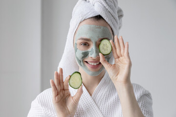 Close up of young smiling woman covering eyes with cucumbers. Advertising poster of fresh healthy skincare mask. Home skin care concept