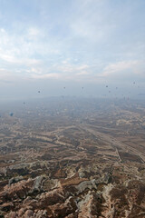 Colorful hot air balloon ride and tour in Goreme valley, semi-arid region in central Turkey known for its distinctive fairy chimneys, tall, cone-shaped rock formation- Cappadocia, Turkey