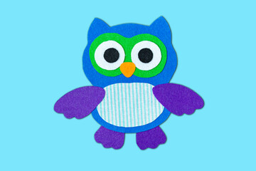 Craft, applique of an owl from multi-colored felt. Creative classes with children. Sewing soft toys, hobby.