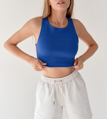 close up portrait woman wears blue crop top and white shorts copy space. indoor lifestyle young girl