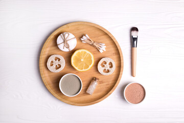 Cosmetic clay facial masks, sea salt, lemon and brush on white background.