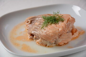 Canned salmon chunks with lettuce leaves,on white plate