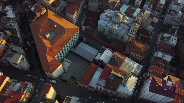 The narrow streets of Istanbul from a bird's eye view. Rooftops reflect sunset in the evening, seagulls fly over residential buildings in Turkey.