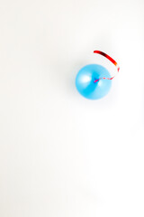 A blue balloon with a red string on the ceiling