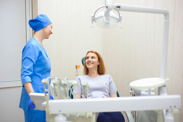 dentist in dental office talking with female patient and preparing for treatment