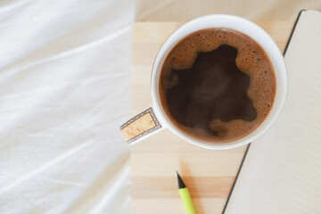 a cup of coffee and notebook and pencil
