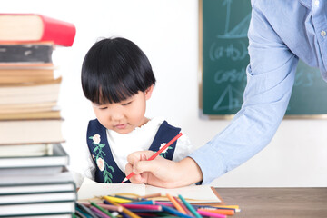 The teacher is tutoring the little girl's homework