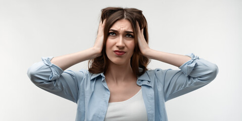 Naklejka premium Image of stressed woman with long chestnut hair grabbing her head. Emotional helplessness. Studio shot, white background