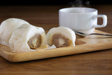 Steamed bun and hot coffee in the wooden tray Chinese snack on brown wooden table
