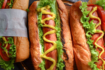 Hot dogs with various fillings. Dark background. food background with copy space. Top view. Hot dogs with mustard and ketchup, lettuce, cheese and tomatoes. Closeup