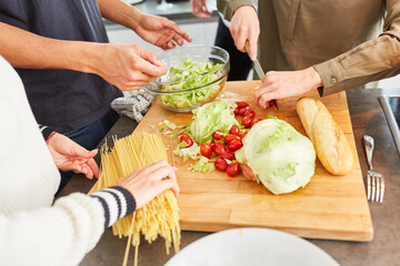 Studenten bereiten Pasta und Salat in Küche zu
