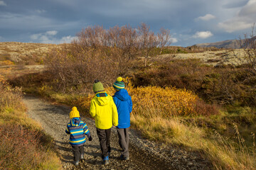 Fototapeta na wymiar Children, brothers, walking on a path in scenic Thingvellir National Park rift valley, Iceland