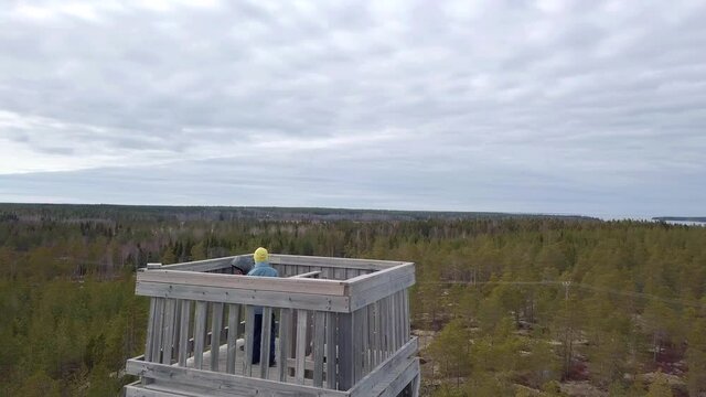 Boys up in a wooden outlook tower overlooking world, aerial