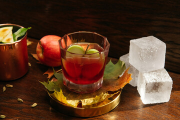 Autumn whisky cocktail with apple, lime and ice on the table in restaurant