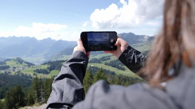 Photography - Switzerland Tourist Taking Picture on Smartphone of Scenic Overlook in Mountains