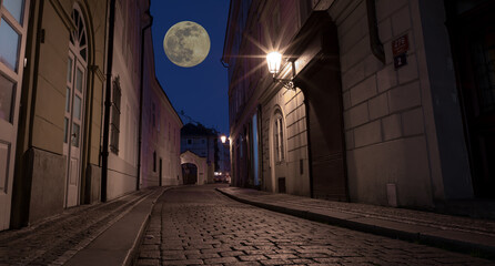 Prague night street with moon in the sky. Elements of this image furnished by NASA.