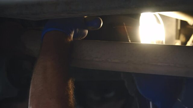 a man hitting a tube with a screwdriver and an hammer