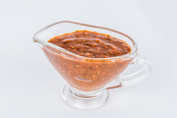 BBQ sauce in a transparent gravy boat shot on a white background