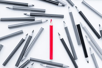 one red pencil among black and white. business concept