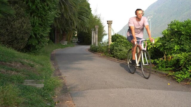 Guy drives a single-speed &ldquo;fixie&rdquo; bicycle in his hallway. Exploring new places surrounded by green lush nature.