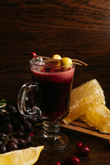 Mulled wine with berries, lemon and honey on the table in restaurant
