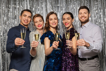 celebration and holidays concept - happy friends toasting champagne glasses at party