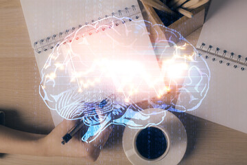 Multi exposure of woman's writing hand on background with brain hologram. Concept of brainstorming.