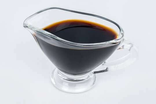 Soy sauce in a transparent gravy boat shot on a white background
