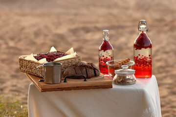 Composition on the table with different products. Sliced rye bread next to a basket of cranberries.