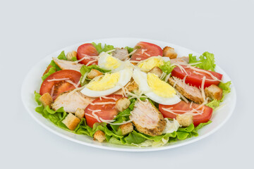 Caesar salad with fresh herbs in a white plate