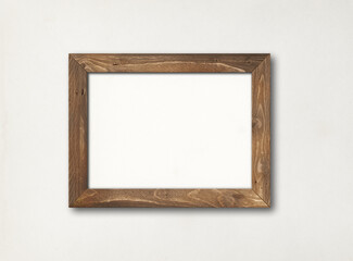 Old rustic wooden picture frame hanging on a white wall