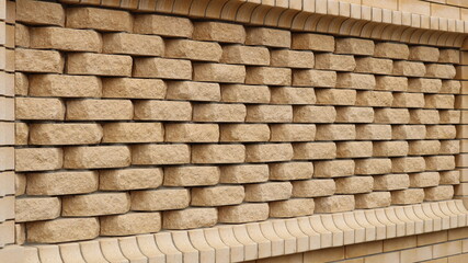 decor of the brickwork pattern of smooth and textured sand-colored bricks as a fragment of the exterior design