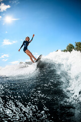 view on beautiful smiling woman actively ride surfboard on the wave