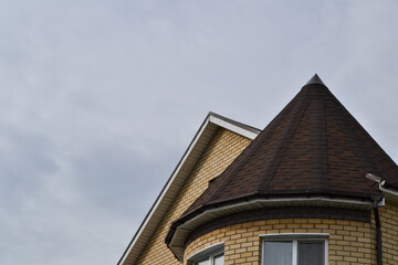 the conical roof of the house is brown.