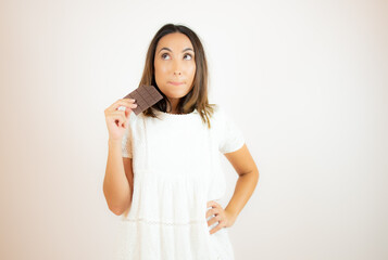 Woman eating a chocolate bar with a funny expression