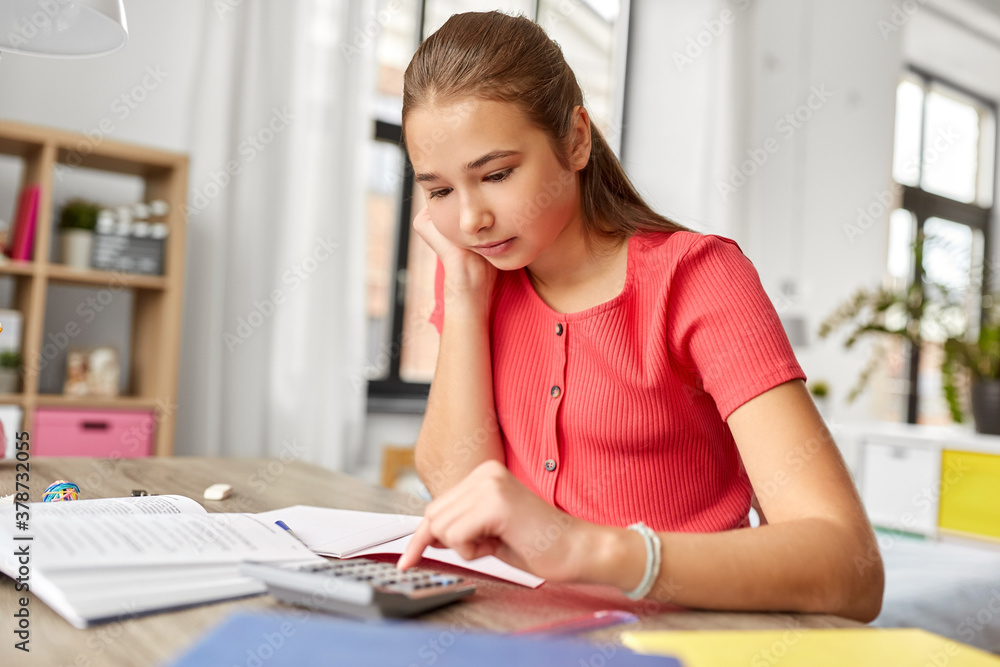 Wall mural children, education and learning concept - teenage student girl counting on calculator at home