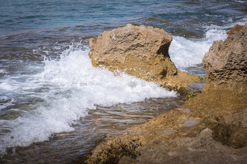 Sea foam from waves breaking against the rocks